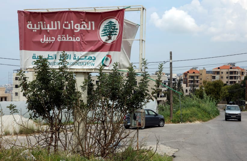  A car drives past a billboard that reads: ' The Lebanese Forces. Byblos area', in Byblos, Lebanon April 8, 2024. (photo credit: REUTERS/MOHAMED AZAKIR)