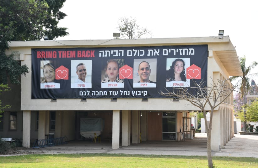  On Kibbutz Nahal Oz, a community center has a large banner calling to bring the hostages home. Seven people were kidnapped from the community, and five have returned. (photo credit: SETH J. FRANTZMAN)