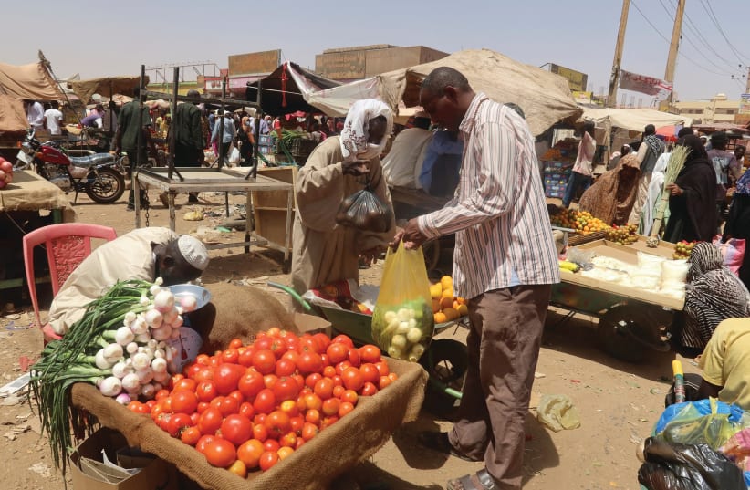  A MAN buys vegetables from a local vendor during the month of Ramadan in Omdurman, Sudan. Nearly 20 million people, almost one out of every two Sudanese, are facing acute food insecurity in a country that used to be a major food producer, the writers note. (photo credit: EL TAYEB SIDDIG/REUTERS)
