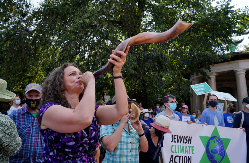  Rabbi Jennie Rosenn blows the shofar at the "Jewish Climate Action, Hear The Call Senator Schumer" event in New York City on September 12, 2021. (photo credit: Jemal Countess / Getty, courtesy of Dayenu)