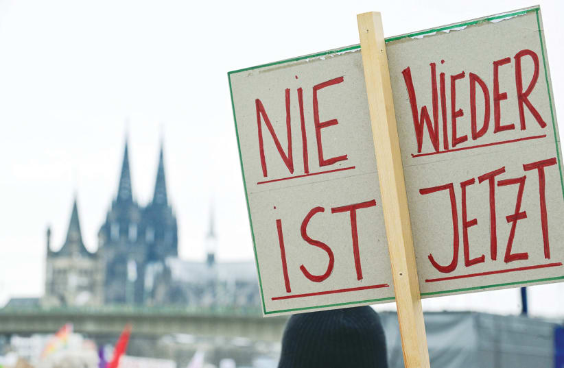  A DEMONSTRATOR holds a sign that reads “Never Again is Now” during a protest against right-wing extremism and the far-Right opposition Alternative for Germany (AfD), in Cologne, in January.  (photo credit: Jana Rodenbusch/Reuters)