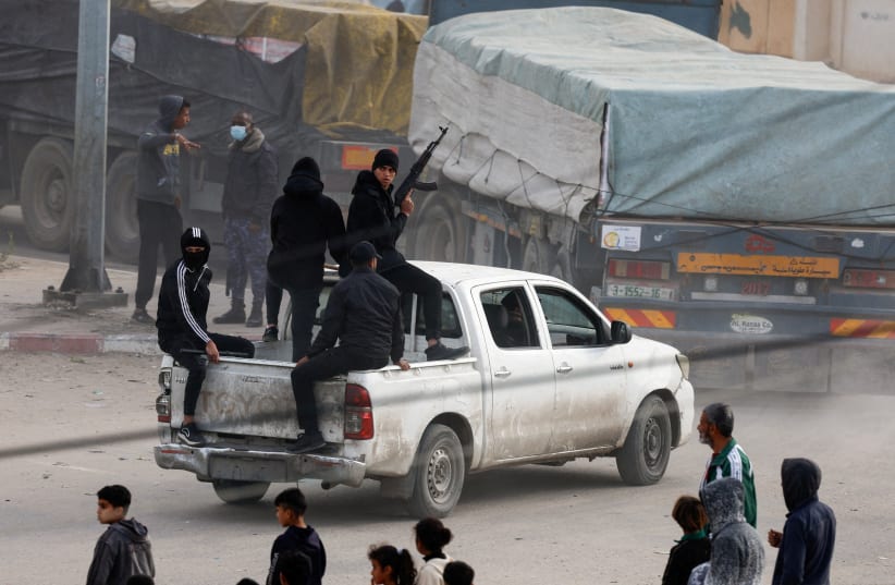 Security personnel guard trucks carrying aid as they arrive in Rafah, amid the ongoing conflict between Israel and the Palestinian Islamist group Hamas, in the southern Gaza Strip January 17, 2024. (photo credit: REUTERS/MOHAMMED SALEM/FILE PHOTO)