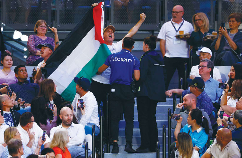  SECURITY PERSONNEL eject from the stands a fan displaying a flag in support of Palestine during the women’s final match at the Australian Open tennis tournament in Melbourne, in January. (photo credit: Issei Kato/Reuters)