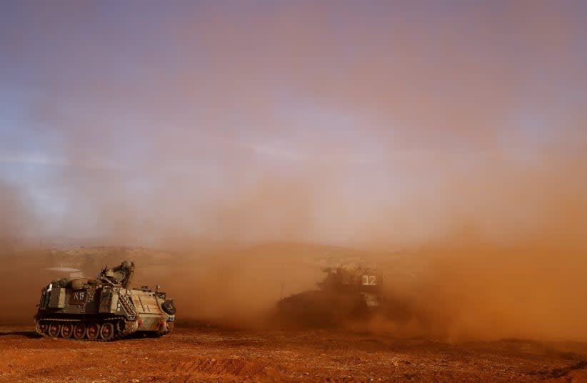  Un vehículo blindado de transporte de tropas (APC) israelí y un tanque israelí participan en un simulacro cerca de la frontera de Israel con Líbano, en el norte de Israel, 26 de octubre de 2023. (photo credit: LISI NIESNER/ REUTERS)