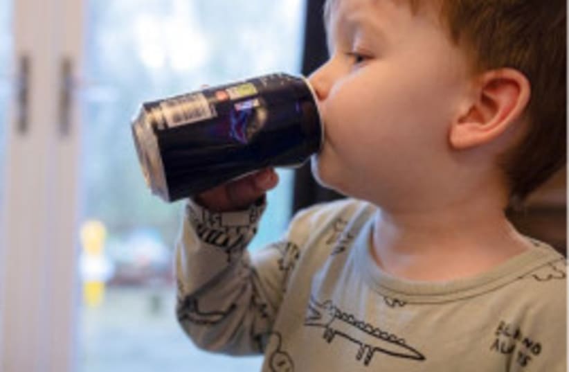 Un niño pequeño bebiendo una bebida azucarada y gaseosa.  (photo credit: Swansea University )