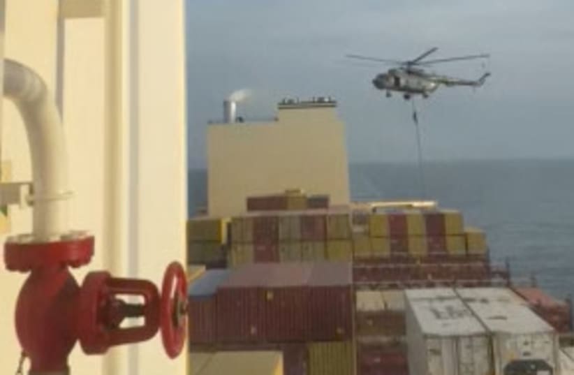 Un funcionario se desliza por una cuerda durante una incursión en helicóptero en el buque MSC Aries en alta mar en esta captura de pantalla obtenida de un vídeo difundido en las redes sociales el 13 de abril de 2024. (photo credit: REUTERS)