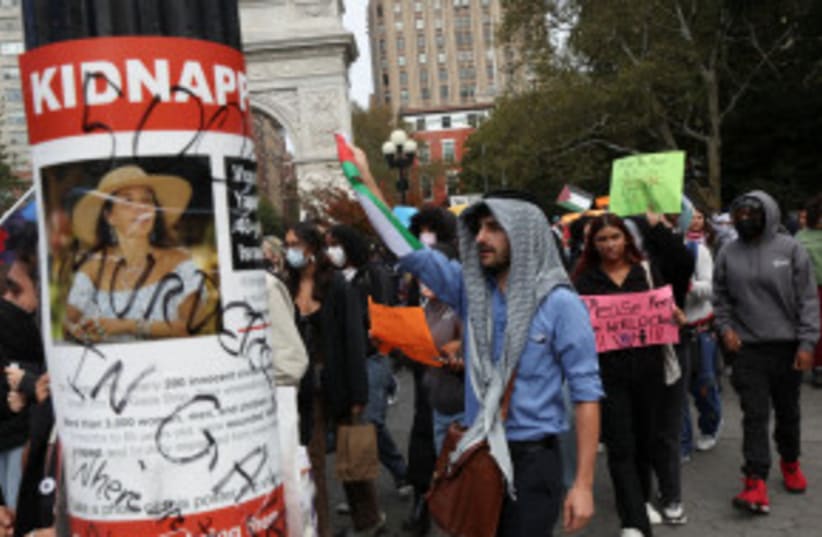 Personas en una manifestación de solidaridad con los palestinos en Gaza, parte de un paro estudiantil en la Universidad de Nueva York, EE. UU., el 25 de octubre de 2023, sosteniendo un cartel que dice "secuestrada". (photo credit: Shannon Stapleton/Reuters)