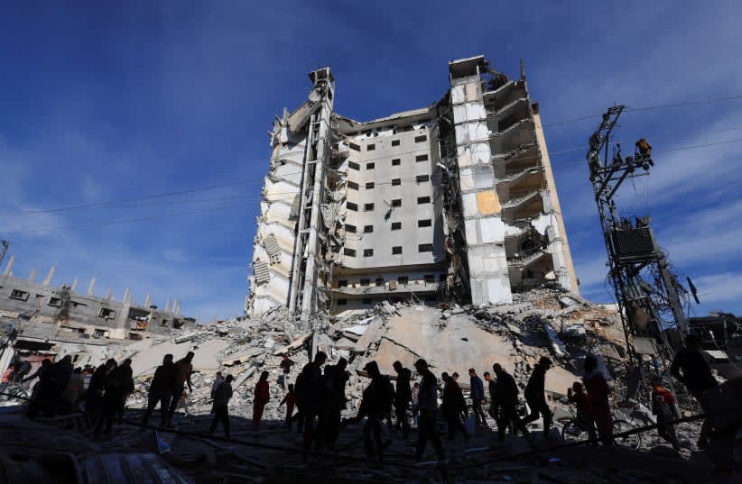  Palestinos se reúnen cerca de un edificio dañado por un ataque aéreo israelí en Rafah, en el sur de la Franja de Gaza 9 de marzo de 2024 (photo credit: MOHAMMED SALEM/REUTERS)