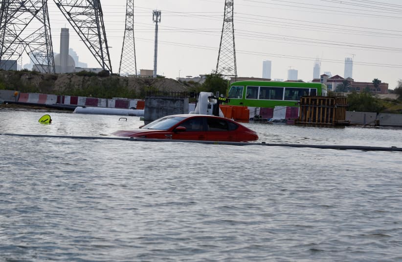  A car is stuck on a flooded road after a rainstorm, in Dubai, United Arab Emirates, April 17, 2024. (photo credit: REUTERS/RULA ROUHANA )