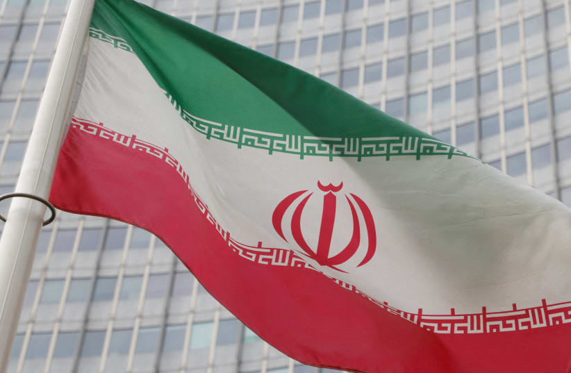   The Iranian flag flutters outside the International Atomic Energy Agency (IAEA) headquarters in Vienna, Austria, March 6, 2023.  (photo credit: REUTERS/LEONHARD FOEGER/FILE PHOTO)
