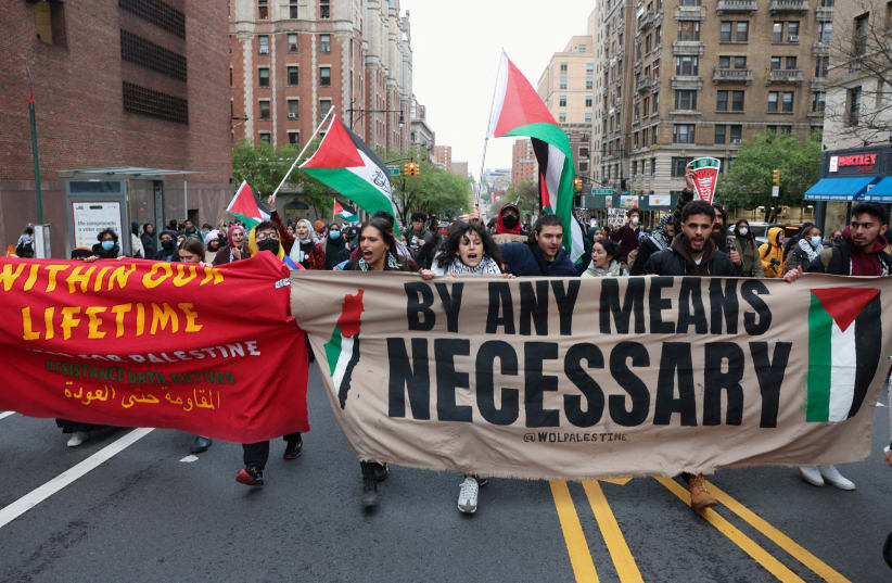 Demonstrators holding a banner protest in solidarity with Pro-Palestinian organizers as they block a street, amid the ongoing conflict between Israel and the Palestinian Islamist group Hamas, in New York City, US, April 18, 2024. (photo credit: REUTERS/CAITLIN OCHS)
