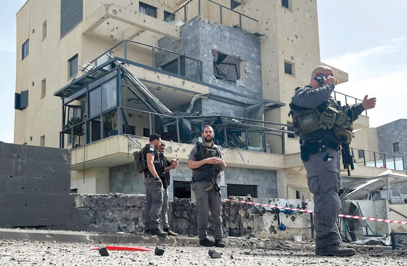  Israeli police work at the site of a lethal rocket strike at a factory in Kiryat Shmona on March 27.  (photo credit: Avi Ohayon/Reuters)