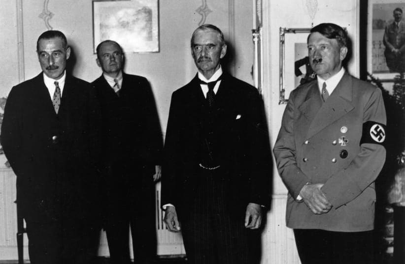  El PRIMER MINISTRO BRITÁNICO Neville Chamberlain (segundo por la derecha) con Adolf Hitler en Múnich en septiembre de 1938 durante la firma del Pacto de Múnich, que accedía a la exigencia de Hitler de que los Sudetes fueran cedidos a Alemania. (photo credit: Photo by Keystone/Getty Images)
