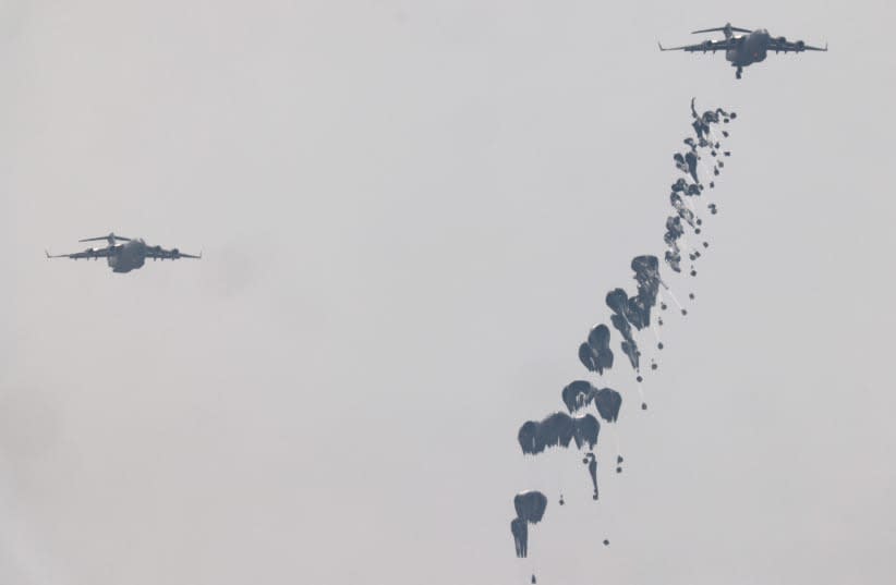  Ayuda humanitaria cae por el cielo hacia la Franja de Gaza tras ser lanzada desde un avión, en medio del actual conflicto entre Israel y el grupo islamista palestino Hamás, vista desde Israel, 29 de marzo de 2024. (photo credit: AMIR COHEN/REUTERS)
