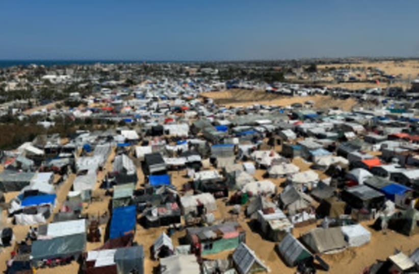 Palestinos desplazados, que huyeron de sus casas debido a los ataques israelíes, se refugian en un campamento de tiendas de campaña, en medio del conflicto en curso entre Israel y el grupo islamista palestino Hamás, en Rafah, en el sur de la Franja de Gaza 11 de marzo 2024. (photo credit: REUTERS/BASSAM MASOUD)