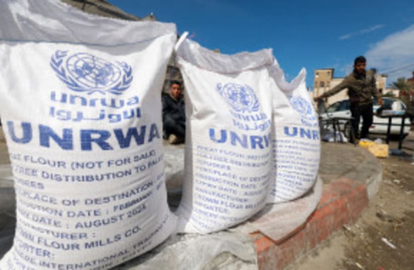 Palestinos desplazados esperan para recibir ayuda de la Agencia de Naciones Unidas para los Refugiados Palestinos (UNRWA), en medio del actual conflicto entre Israel y el grupo islamista palestino Hamás, en Rafah, en el sur de la Franja de Gaza, el 7 de marzo de 2024. (photo credit: MOHAMMED SALEM/REUTERS)