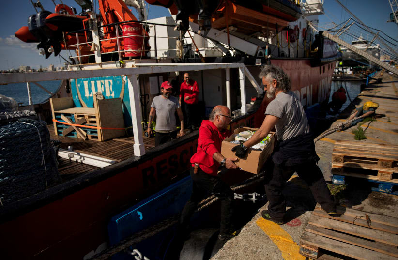  Miembros de Open Arms transportan ayuda humanitaria para Gaza en una misión conjunta de las ONG Open Arms y World Central Kitchen en un puerto de Larnaca, Chipre, 9 de marzo de 2024. (photo credit: Santi Palacios/Open Arms-World Central Kitchen/Handout via REUTERS)