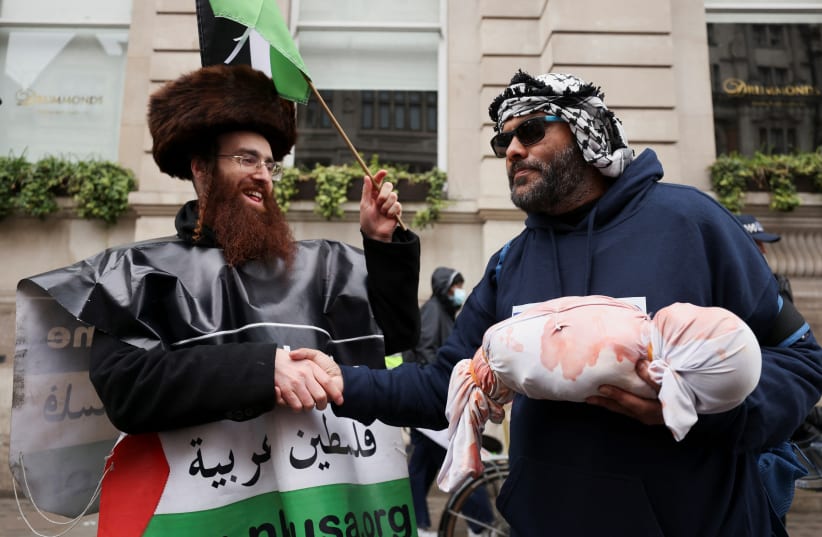  Jewish anti-zionist shakes hands with a pro-Palestinian demonstrator as people gather during a march in solidarity with Palestinians in Gaza, amid the ongoing conflict between Israel and the Palestinian Islamist group Hamas, in London, Britain, April 27, 2024 (photo credit: REUTERS/HOLLIE ADAMS)
