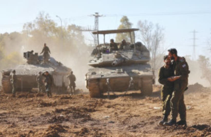 Soldados israelíes se abrazan tras regresar de la Franja de Gaza, en medio del actual conflicto entre Israel y Hamás, en el sur de Israel, 29 de febrero de 2024. (photo credit: AMIR COHEN/REUTERS)