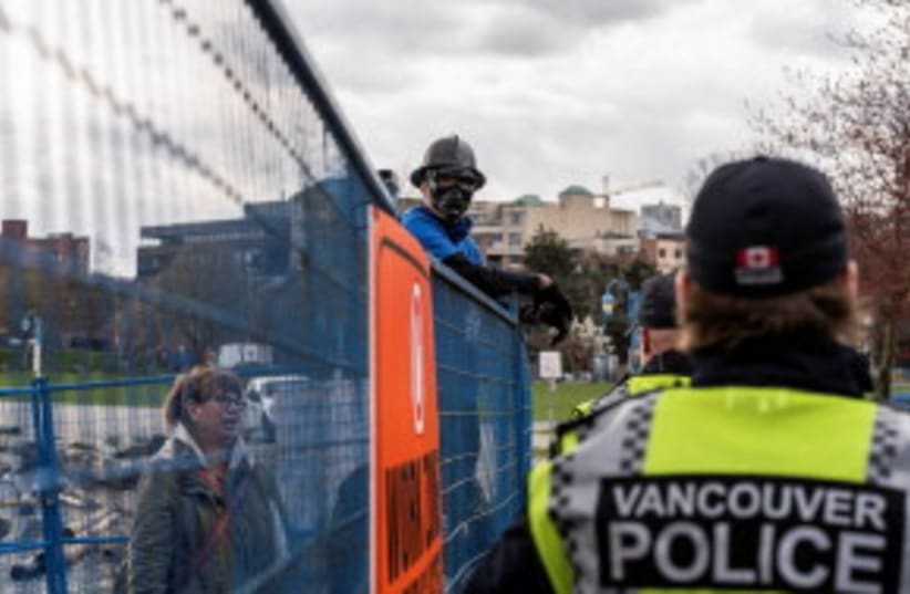  Un residente de Crab Park intercambia palabras con la policía de Vancouver, Vancouver, Columbia Británica, Canadá 25 de marzo de 2024. (photo credit: REUTERS/Paige Taylor White)
