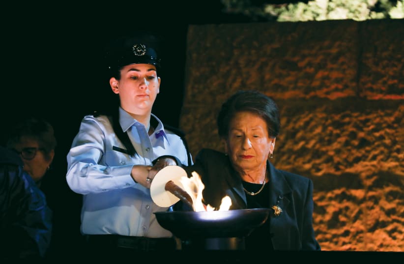  A SURVIVOR lights a torch at Yad Vashem on Holocaust Remembrance Day 2021.  (photo credit: OLIVIER FITOUSSI/FLASH90)