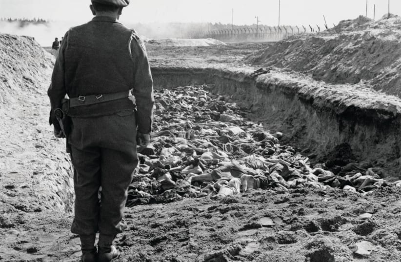  FINAL DIGNITY: Jewish chaplain Rev. Leslie Hardman stands over prisoners’ bodies in a mass grave for burial after the liberation of Bergen-Belsen by units of the British 11th Armoured Division, on April 23, 1945, near Celle, Germany. (photo credit: Harry Oakes/British Army Film and Photographic Unit/Keystone/Hulton Archive/Getty Images)
