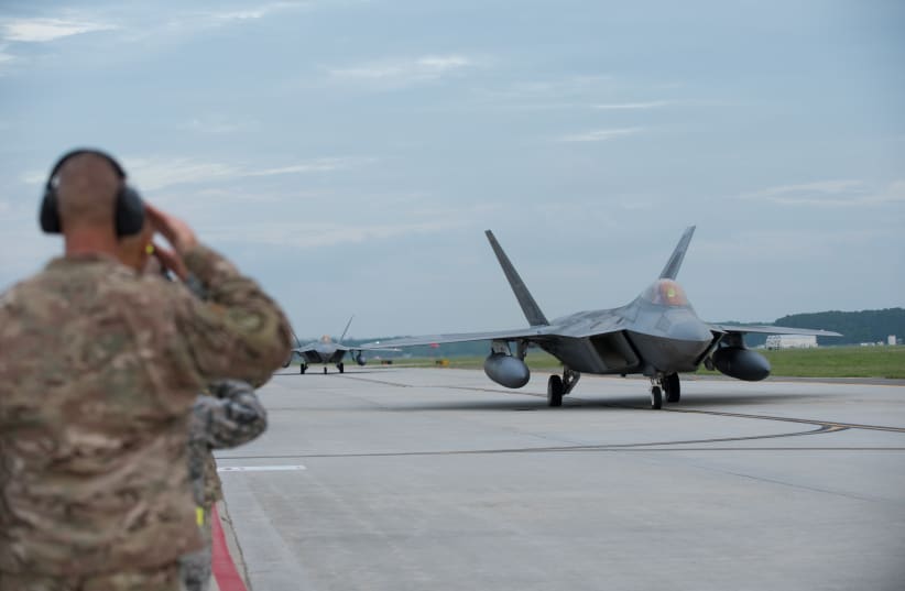  Maintainers and senior leaderships from the 1st Fighter Wing salute F-22 Raptors from the 1st Fighter Wing, 27th Fighter Squadron as it taxis to take-off during a deployment to Al Udeid Air Base, Qatar, from Joint Base Langley-Eustis, Virginia, U.S  (photo credit:  Kaylee Dubois/U.S. Air Force/Handout via REUTERS)