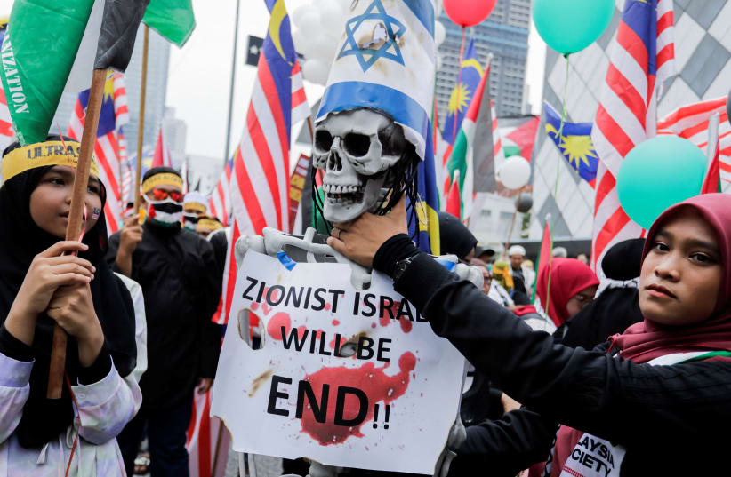  A person holds the neck of an artificial human skeleton during the al-Quds day (Jerusalem Day), an annual pro-Palestinian event held on the last Friday of the Islamic holy month of Ramadan to express support for Palestinians and oppose Israel and Zionism in Kuala Lumpur, Malaysia April 14, 2023 (photo credit: REUTERS/Hasnoor Hussain)