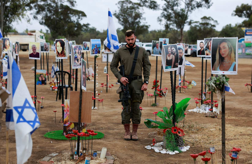 An Israeli soldier stands during a two-minute siren marking the annual Israeli Holocaust Remembrance Day, at an installation at the site of the Nova festival where party goers were killed and kidnapped during the October 7 massacre by Hamas terrorists, in Reim, southern Israel, May 6, 2024.  (photo credit: AMMAR AWAD/REUTERS)