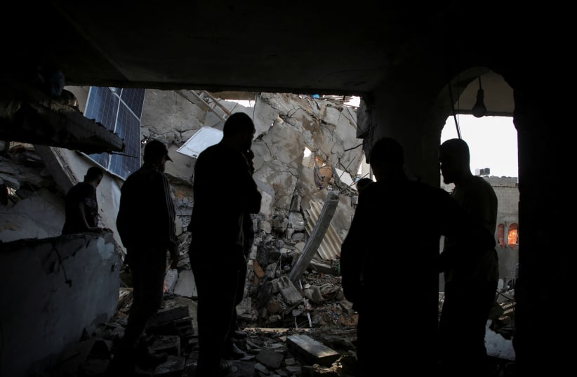  A Palestinian man inspects a house hit in an Israeli strike in Rafah, in the southern Gaza Strip, May 7, 2024 (photo credit: REUTERS/Hatem Khaled)