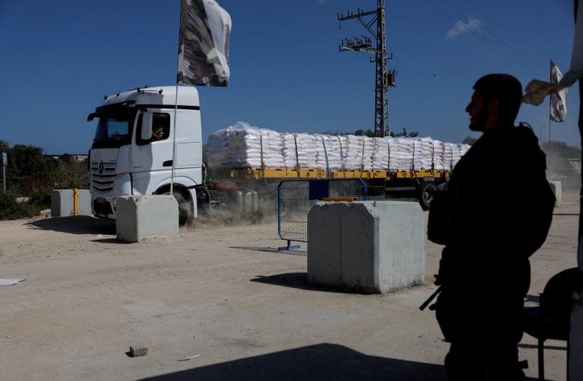  An Israeli soldier stands guard as a truck carrying humanitarian aid makes its way to the Gaza Strip at Erez Crossing in southern Israel, May 5, 2024. (photo credit: REUTERS/AMIR COHEN)