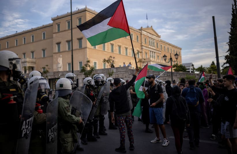 A man waves a Palestinian flag as Palestinians and pro-Palestinian demonstrators protest next to the Greek parliament, amid the ongoing conflict between Israel and the Palestinian Islamist group Hamas, in Athens, Greece, May 7, 2024.  (photo credit: ALKIS KONSTANTINIDIS / REUTERS)