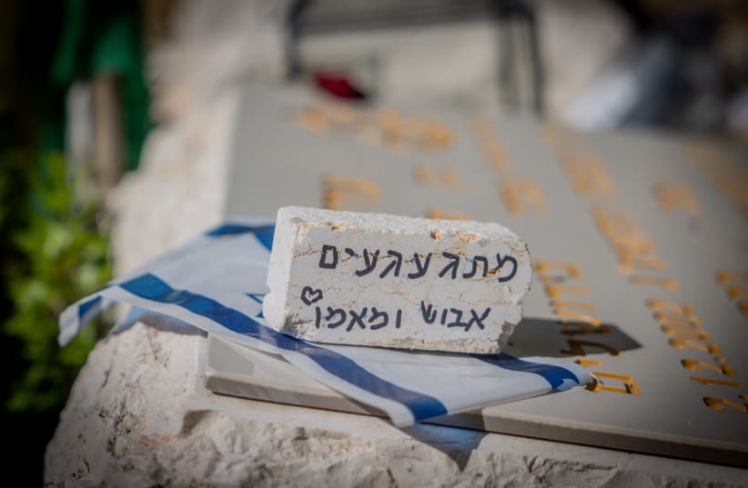  Friends and family members mourn near graves of Israeli soldiers on October 7,  at Mount Herzl Military Cemetery in Jerusalem, on May 9, 2024 (photo credit: Chaim Goldberg/Flash90)