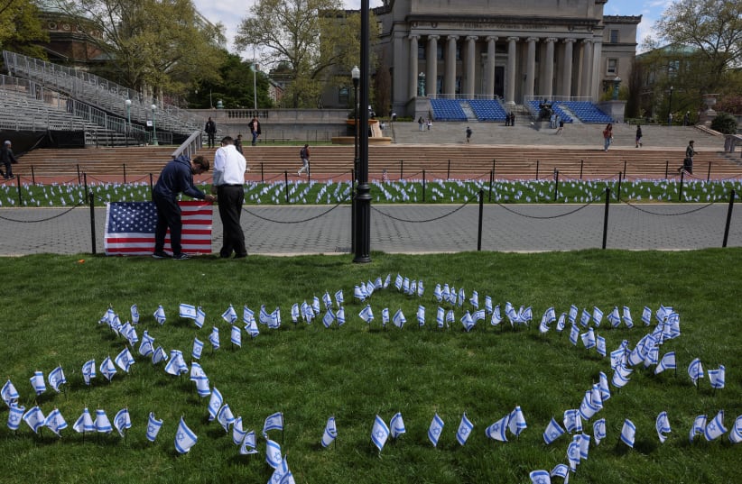  Students place flags near the main lawn of Columbia University, to show support for the Jewish community on campus, for peaceful solutions, and commemorate all lives lost since October 7, 2023, across from a student protest encampment in support of Palestinians, during the ongoing conflict between  (photo credit: REUTERS/CAITLIN OCHS)