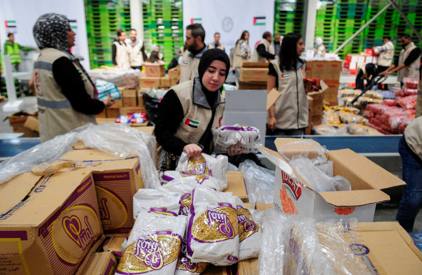  Voluntarios de la Media Luna Roja de los Emiratos preparan paquetes con ayuda humanitaria para Gaza que serán transferidos a través del paso fronterizo de Rafah entre Egipto y la Franja de Gaza, en El Cairo, Egipto, el 30 de marzo de 2024. (photo credit: REUTERS/SHOKRY HUSSEIN)