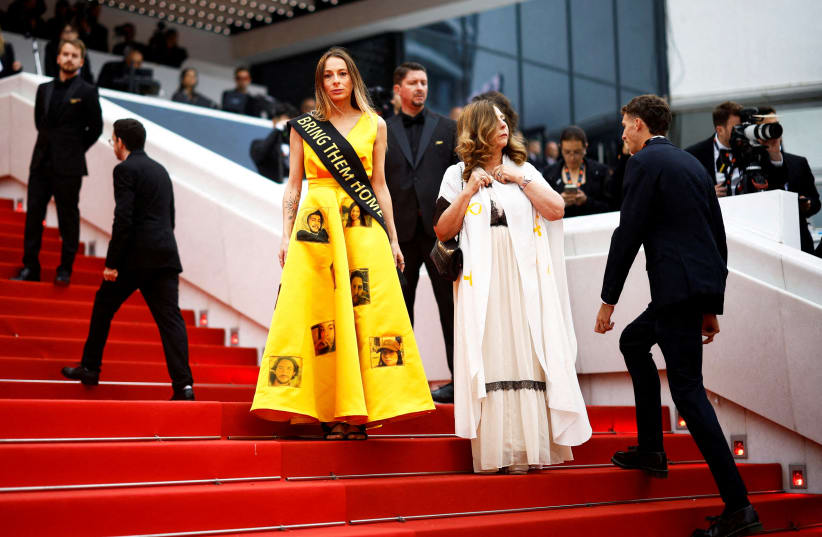 Laura Blajman-Kadar, survivor of the October 7 attack wearing a scarf reading "Bring them home" and a dress with portraits of the hostages, protests on the red carpet, amid the ongoing conflict between Israel and the Palestinian terrorist group Hamas in Gaza. (photo credit: Stephane Mahe/Reuters)