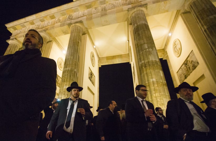  Participants of the Conference of European Rabbis carry candles and chant as they commemorate the 75th anniversary of Kristallnacht in front of Brandenburg Gate in Berlin. (photo credit: THOMAS PETER/REUTERS)