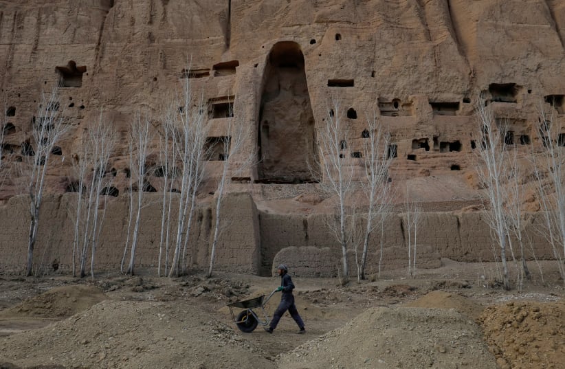  An Afghan man works in front of the ruins of a 1500-year-old Buddha statue in Bamiyan, Afghanistan, March 2, 2023. (photo credit: REUTERS)