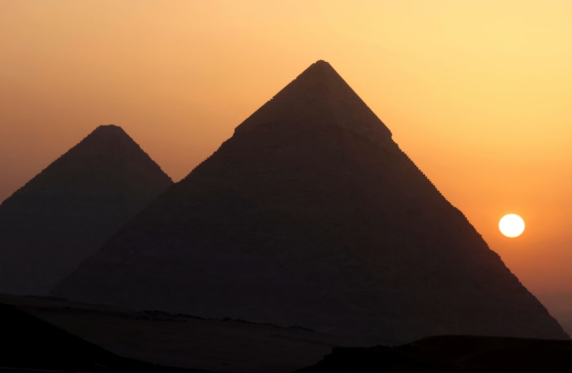  The sun rises behind the Pyramids in Giza, on the outskirts of Cairo, Egypt, June 16, 2023.  (photo credit: REUTERS/MOHAMED ABD EL GHANY)