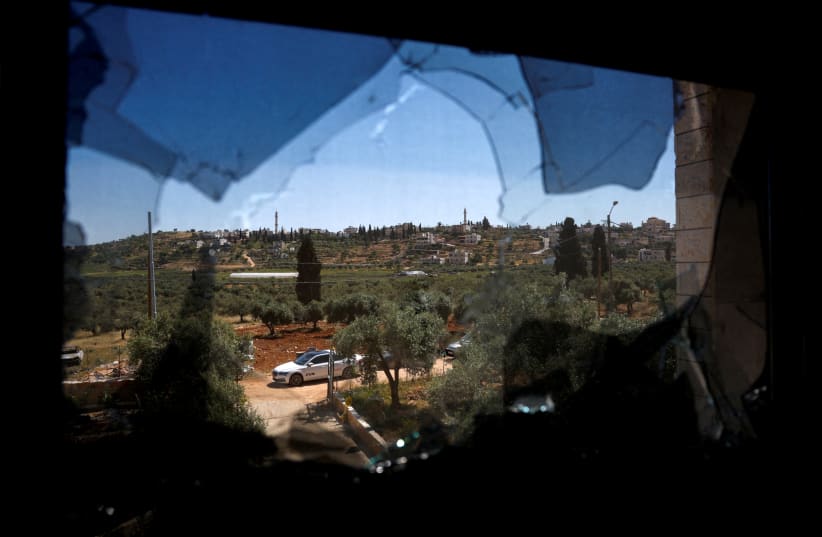  A view shows the village of al-Mughayyer through a damaged window after Israeli settlers attacked the village, in the Israeli-occupied West Bank, April 17, 2024. (photo credit: REUTERS/Mohammed Torokman)