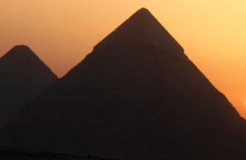  El sol sale detrás de las pirámides de Giza, en las afueras de El Cairo, Egipto, el 16 de junio de 2023. (photo credit: REUTERS/MOHAMED ABD EL GHANY)