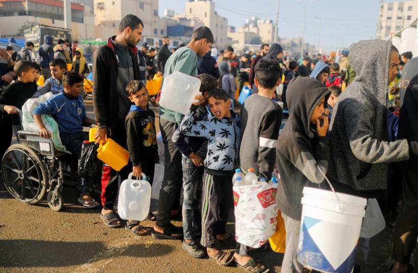   Palestinians queue as they wait to collect drinking water, amid shortages of drinking water, as the conflict between Israel and Hamas continues, in Rafah, in the southern Gaza Strip January 4, 2024. (photo credit:  REUTERS/Saleh Salem/File Photo)