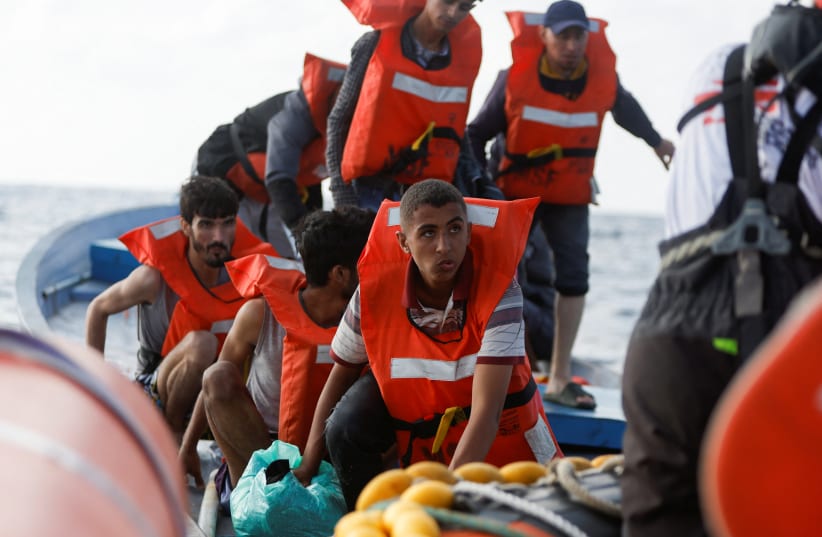 Migrantes de una embarcación de madera son rescatados por el buque Geo Barents de MSF cerca de Libia el 28 de septiembre de 2023. (photo credit: REUTERS/DARRIN ZAMMIT LUPI)