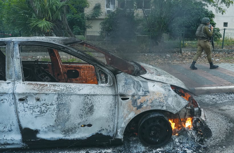 A SOLDIER passes by a burned-out car in Kiryat Shmona in the aftermath of a rocket attack on the northern Israeli city, earlier this month. Since the conflict began, northern Israel has come under repeated rocket and drone attacks from Lebanon, the writer notes. (photo credit: AYAL MARGOLIN/FLASH90)