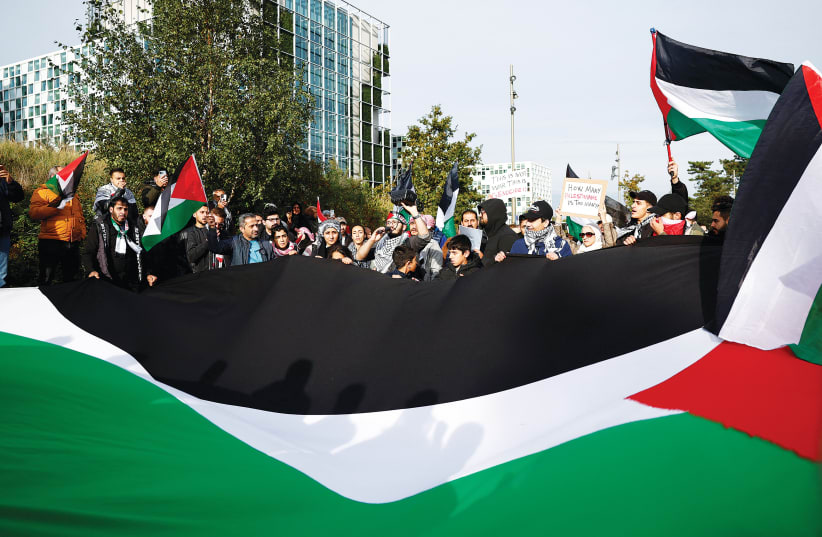  HAMAS SUPPORTERS protest at the headquarters of the International Criminal Court (ICC) in The Hague, Netherlands, soon after the Gaza war was launched in October, last year.  (photo credit: PIROSCHKA VAN DE WOUW/REUTERS)