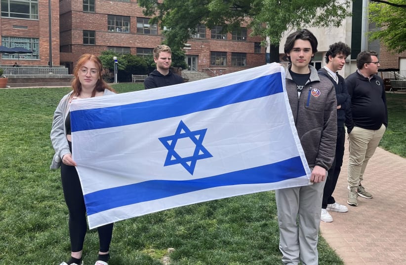  Philosophy student Skyler Sieradzky, 21, left, holds an Israeli flag as pro-Palestinian protesters stage a sit-in on the urban campus of George Washington University in Washington, DC in April.  (photo credit: Maria DANILOVA / AFP)