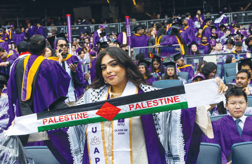  A STUDENT holds a Palestinian scarf at the New York University (NYU) graduation ceremony at Yankee Stadium in the Bronx borough of New York City, earlier this month. (photo credit: Eduardo Munoz/Reuters)
