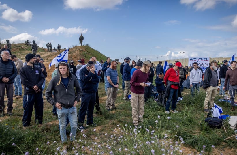  Fuerzas de seguridad israelíes vigilan mientras la gente protesta contra la entrada de camiones de ayuda en la Franja de Gaza, en el paso fronterizo de Kerem Shalom, en el sur de Israel, 29 de enero de 2024. (photo credit: Chaim Goldberg/Flash90)