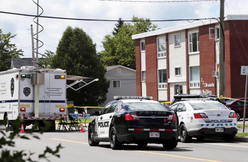  La Policía de Fredericton y la Real Policía Montada de Canadá (RCMP) investigan el complejo de apartamentos que fue escenario de un tiroteo en Fredericton, Nuevo Brunswick, Canadá 10 de agosto de 2018. (photo credit: REUTERS/Dan Culberson)