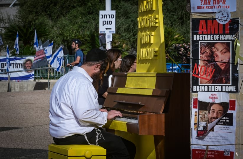  Un judío ultraortodoxo toca el piano en la "Plaza de los Rehenes" de Tel Aviv, 23 de noviembre de 2023. (photo credit: AVSHALOM SASSONI/FLASH90)